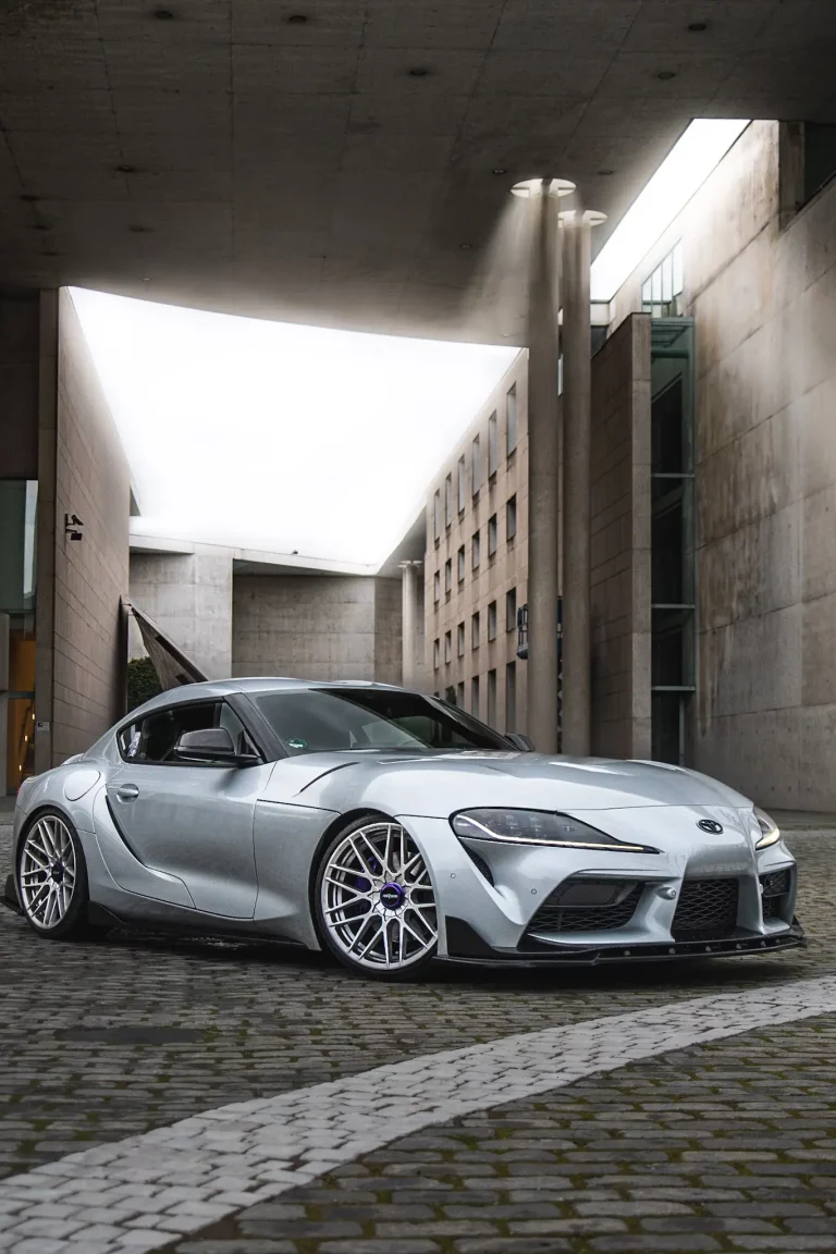 Ein silbener Toyota Supra GR mk5 vor riesige Mauern und ein tolles Licht. Bild bei Tobias Adrian Küpper La Torre - pandalor